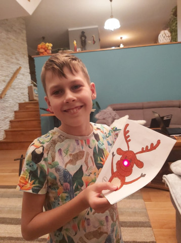 Chłopiec z wykonaną przez siebie kartką świąteczną