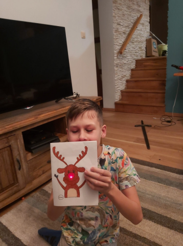 Chłopiec z wykonaną przez siebie kartką świąteczną
