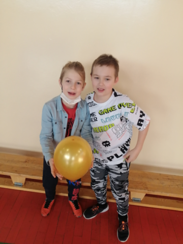 Dwóch chłopców bawi się żółtym balonem