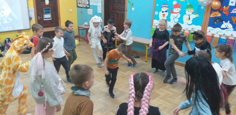 klasa 2b bawi się wspólnie w kółeczku, w środku tańczy Julek, inne dzieci naśladują jego ruchy
