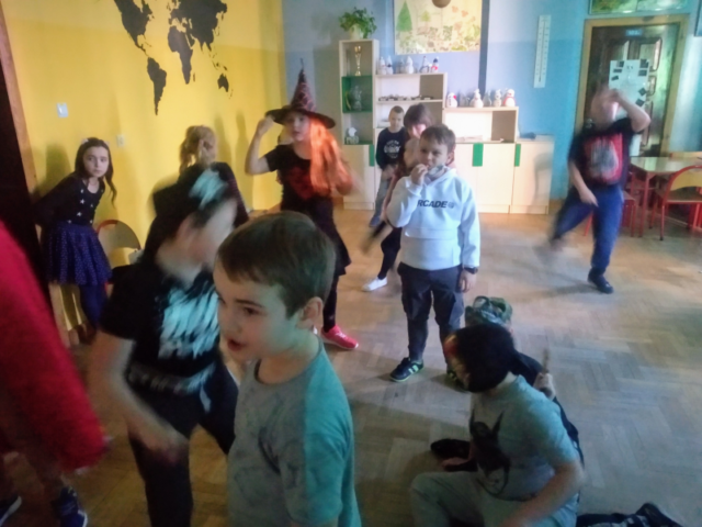 Przebrane dzieci tańczą i bawią się na balu karnawałowym
