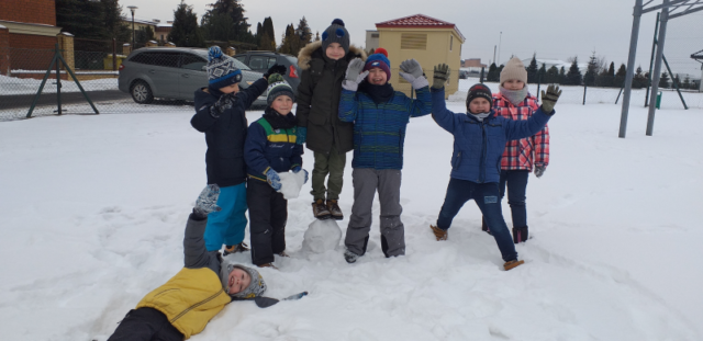 chłopcy z klasy 2b i Zosia  pozują podczas zabawy bryłami śniegu