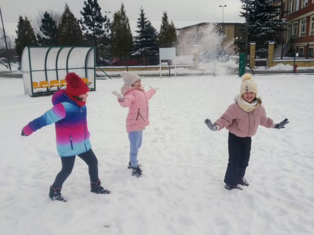 Dziewczynki rzucają się puszystym śniegiem