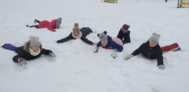 dziewczyny z 2b robią orły na śniegu leżąc na brzuszkach