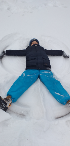 Chłopiec z 2b robi aniołka leżąc na śniegu