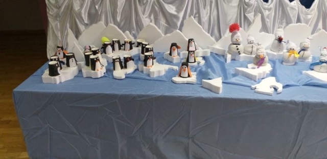 Papierowe pingwiny wykonane przez dzieci. Pingwiny umieszczone są na krach lodowych zrobionych ze styropianu