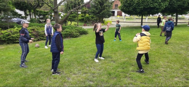 Uczniowie bawią się piłką na dworze