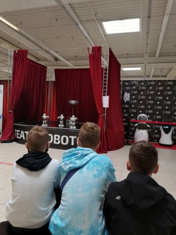 Chłopcy oglądają pokaz tańczących robotów