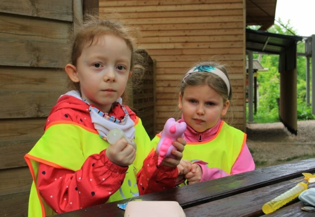 Dziewczynki siedzą przy drewnianym stole