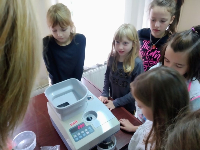 Dziewczynki oglądają maszynę do liczenia pieniędzy.