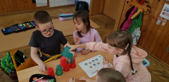 Dzieci układają kolorowe kubki