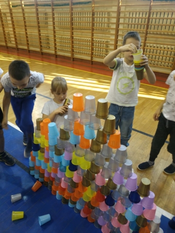 Dzieci budują budowlę z kolorowych kubeczków