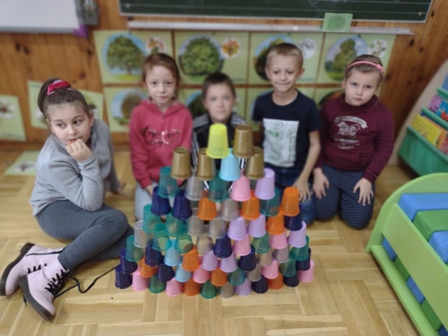 Dzieci prezentują budowlę z kubeczków