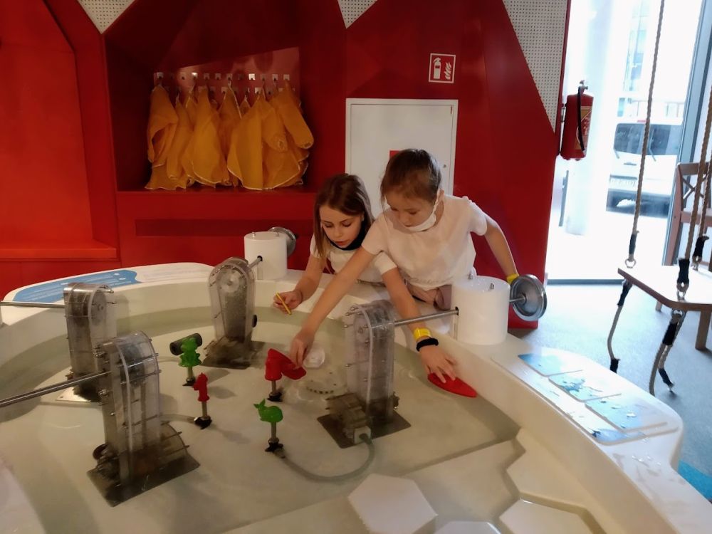 Dziewczynki wykonują eksperymenty z wodą.