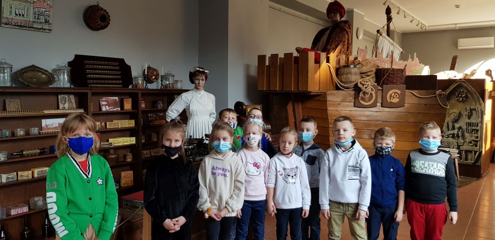 Dzieci stoją przed eksponatami wystawy toruńskich pierników