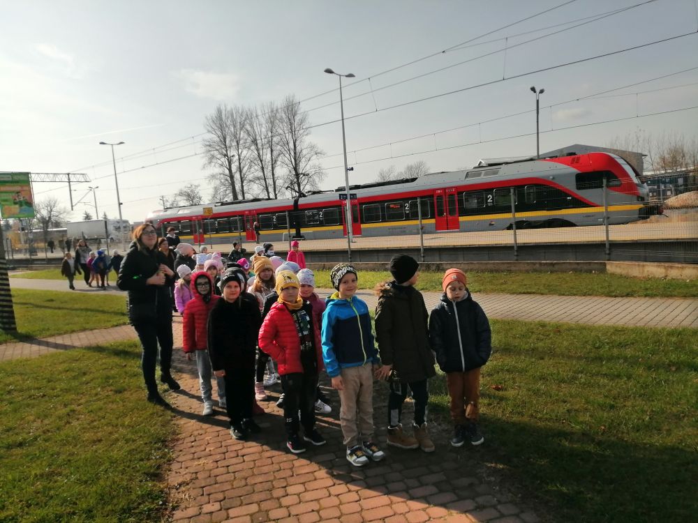 Pierwszoklasiści oglądają róże rodzaje pociągów na dworcu PKP w Radomsku