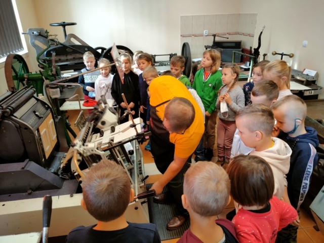 Dzieci oglądają działanie starych maszyn w drukarni