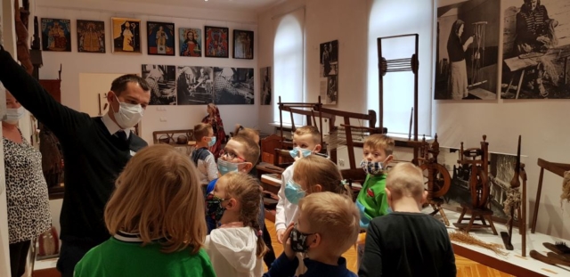 Dzieci oglądają eksponaty dawnej wsi w muzeum.