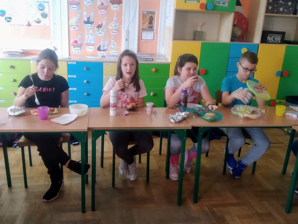 Dzieci jedzą wspólnie śniadanie