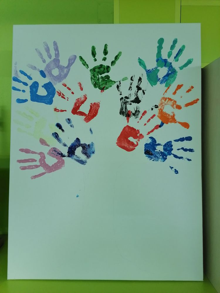 Obraz z odciśniętymi dłońmi uczniów i wychowawcy