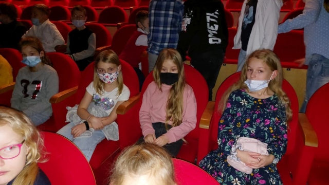 uczniowie siedzą w teatrze