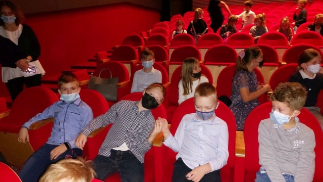 uczniowie siedzą w teatrze