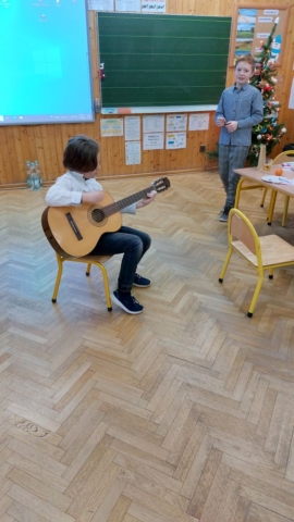 Uczeń gra na gitarze kolędę