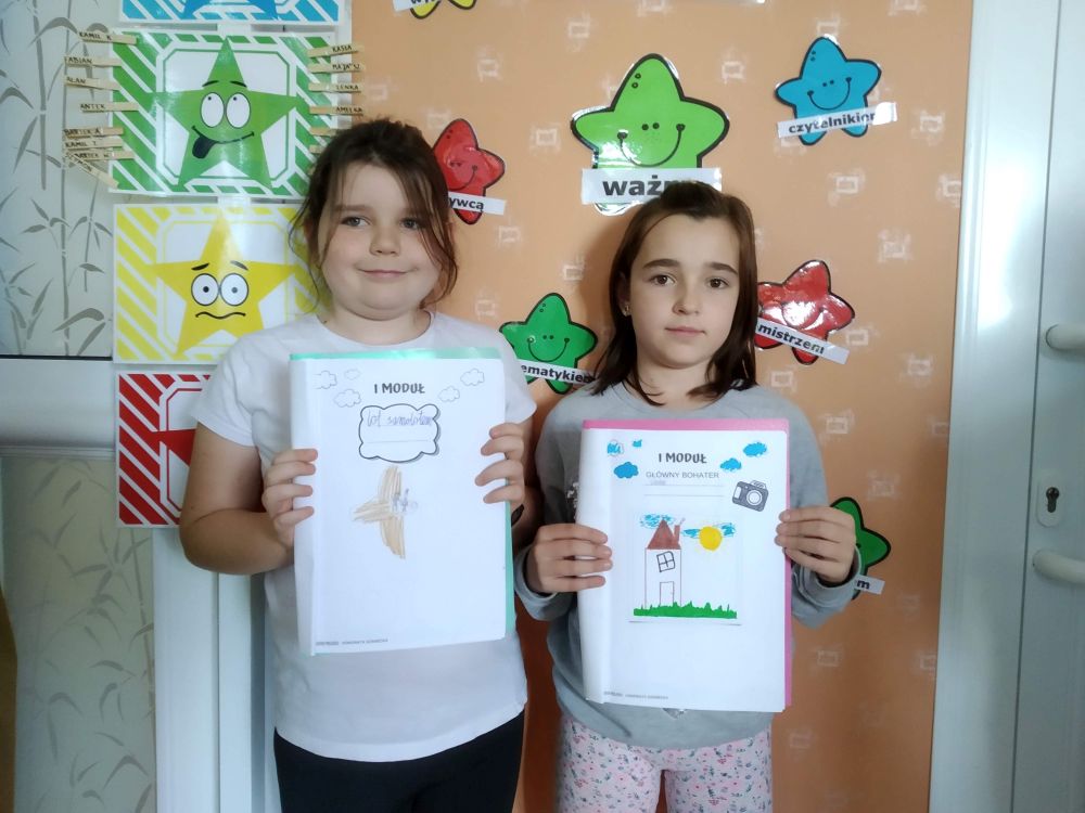 Dziewczynki prezentują swoje rysunki.
