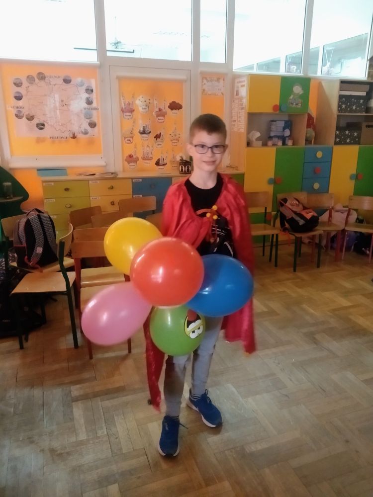 Chłopiec trzyma w ręce kolorowe balony