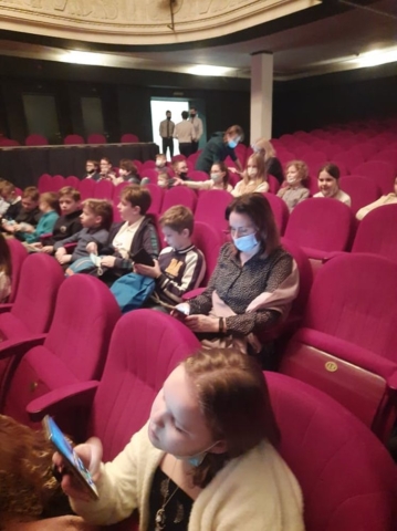 Uczniowie siedzą na teatralnej widowni