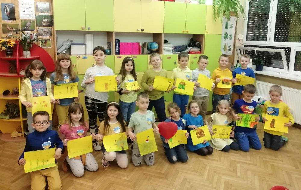 Dzieci trzymają w rękach rysunki dla dzieci z Ukrainy