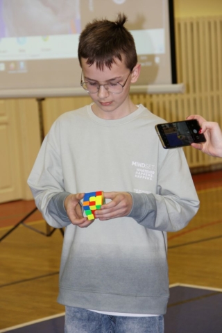 Uczeń prezentuje swój talent - układanie kostki Rubika