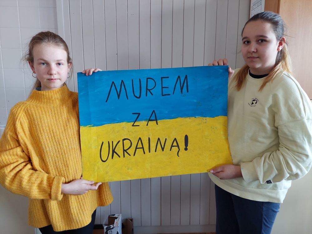 Uczennice klasy Vb trzymające napis Murem za Ukrainą.