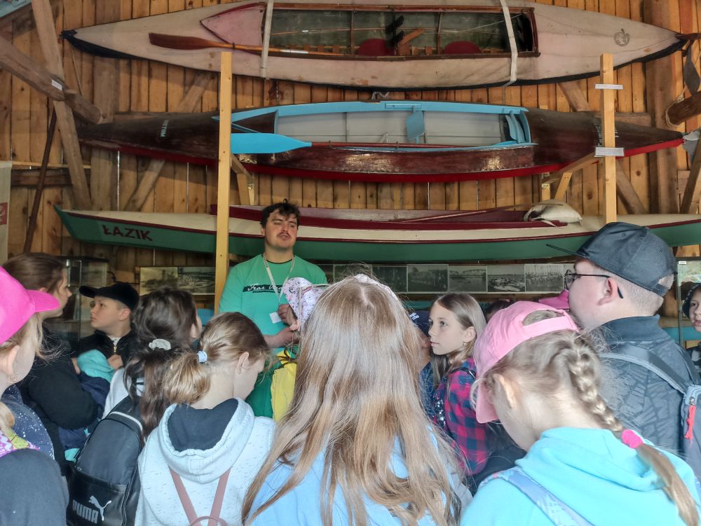 Dzieci słuchają przewodnika w Muzeum Rzeki Pilicy.
