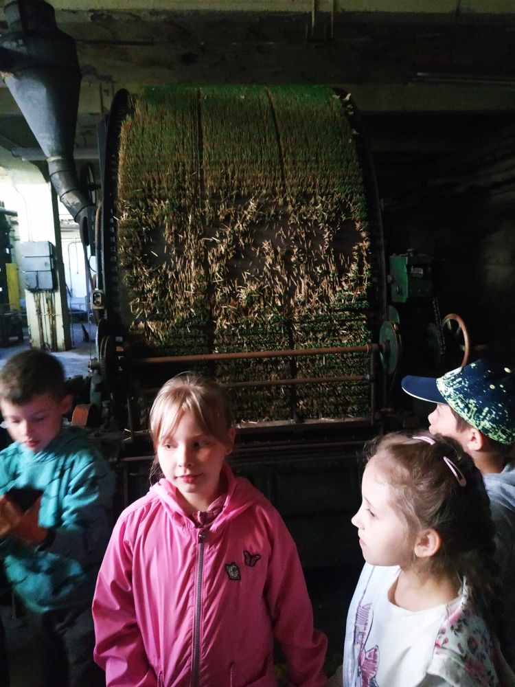Dzieci stoją obok maszyny do wyrobu zapałek