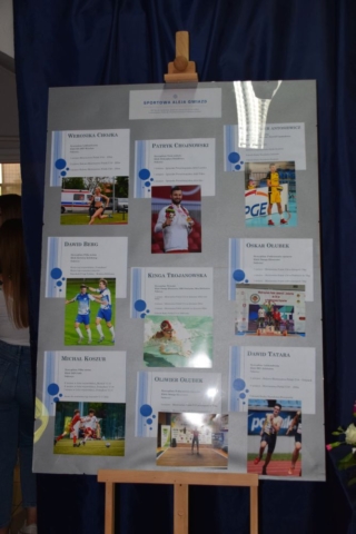 Okolicznościowa wystawa na szkolnym korytarzu poświęcona uczniom, którzy osiągnęli sukcesy w sporcie.