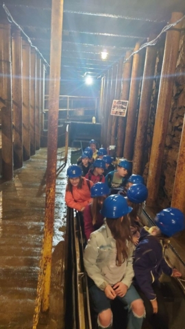 Uczniowie siedzą w łódkach w zabytkowej kopalni srebra