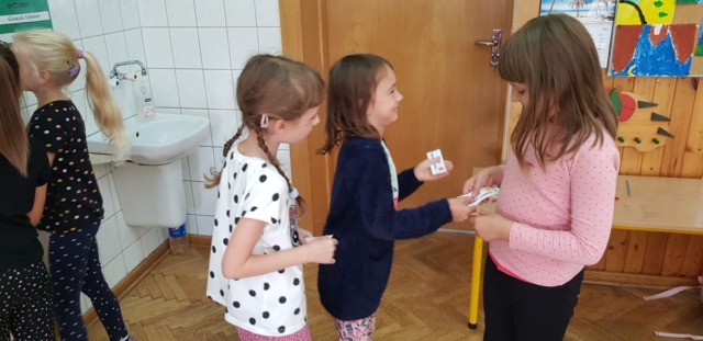 Dziewczynki wręczają sobie miłe karteczki.