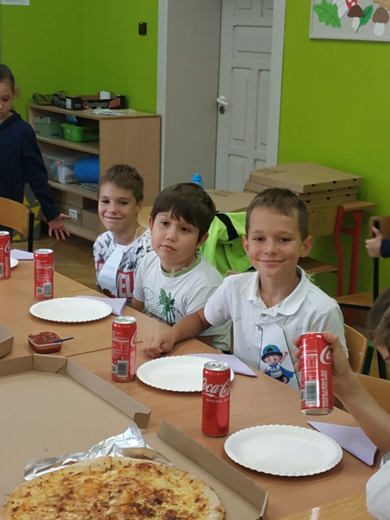 Dzieci jedzą pizzę