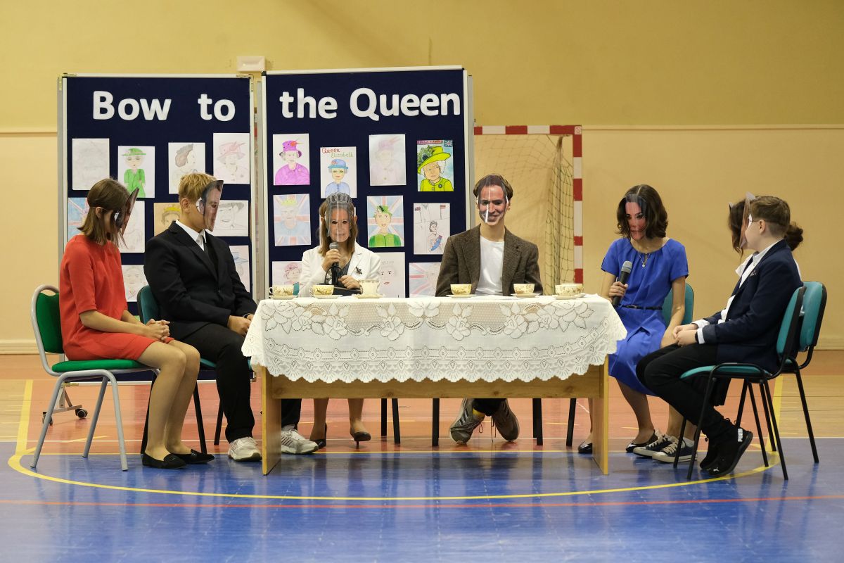 scenka z udziałem brytyjskiej rodziny królewskiej na herbatce u królowej