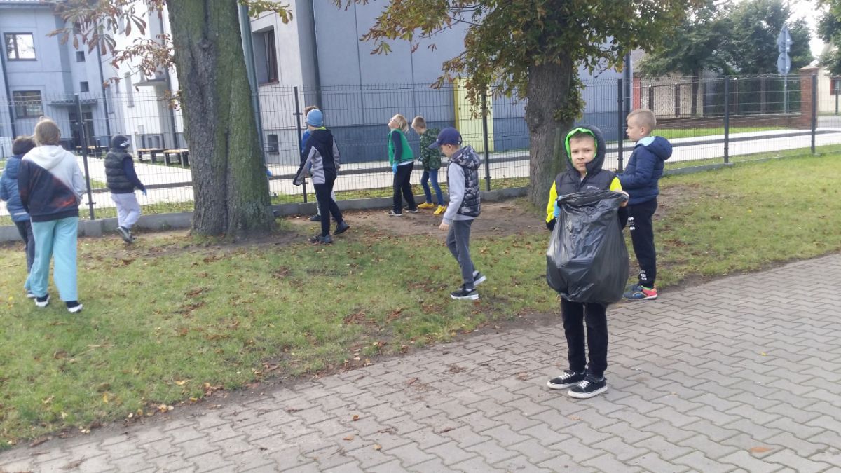 Uczniowie zbierają śmieci wokół szkoły