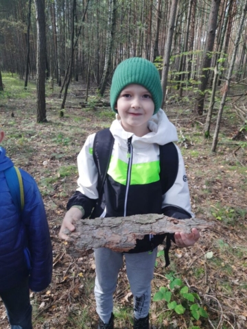 Chłopiec trzyma kawałek kory drzewa