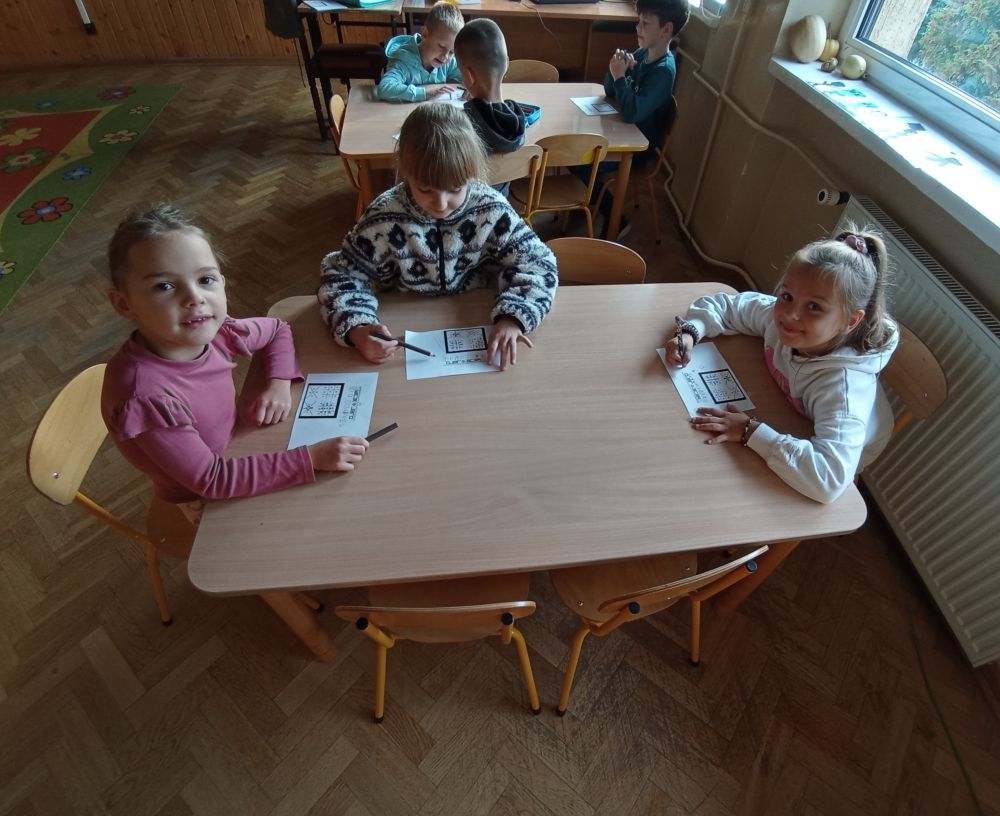 Uczniowie przy stolikach wykonują zadanie
