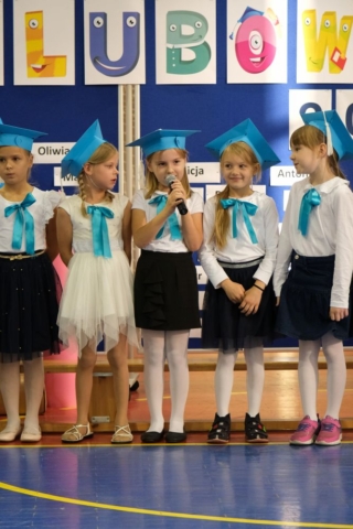 grupa uczniów w niebieskich czapeczkach
