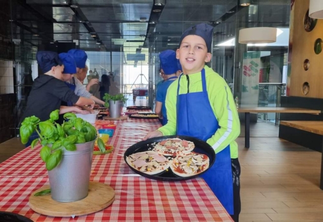 Dzieci prezentują przygotowane własnoręcznie pizze