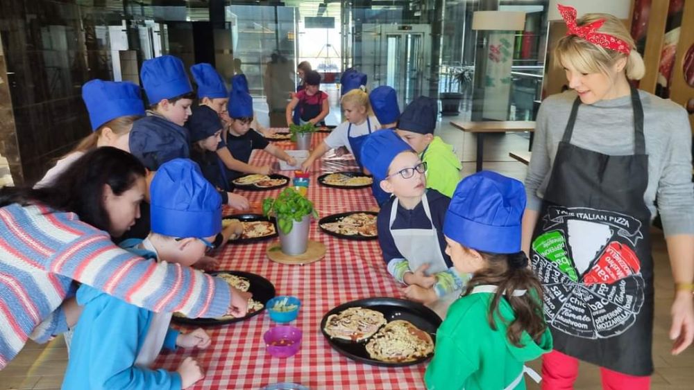 Dzieci prezentują przygotowane własnoręcznie pizze