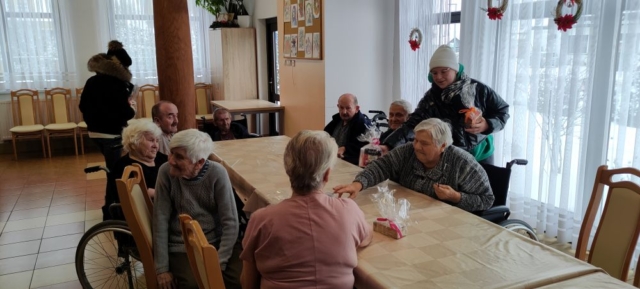 Wolontariusze wręczają herbatę seniorom