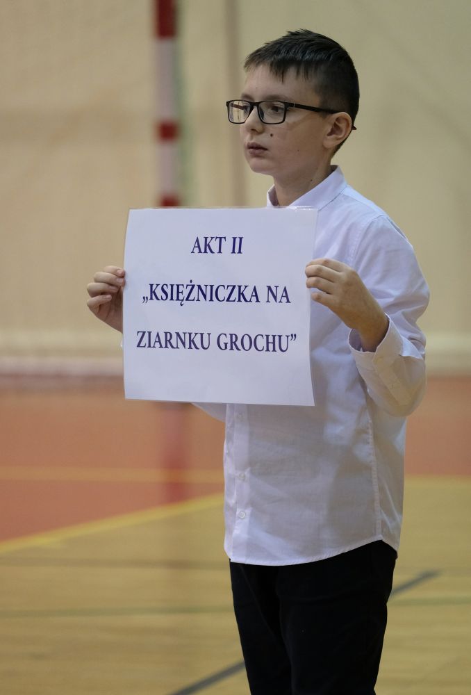 chłopiec trzyma tabliczkę z tytułem baśni