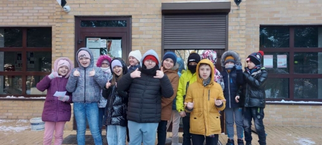 Grupa dzieci przed budynkiem poczty