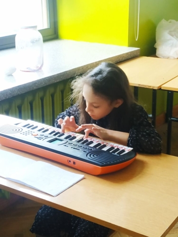 Uczennica gra na instrumencie klawiszowym